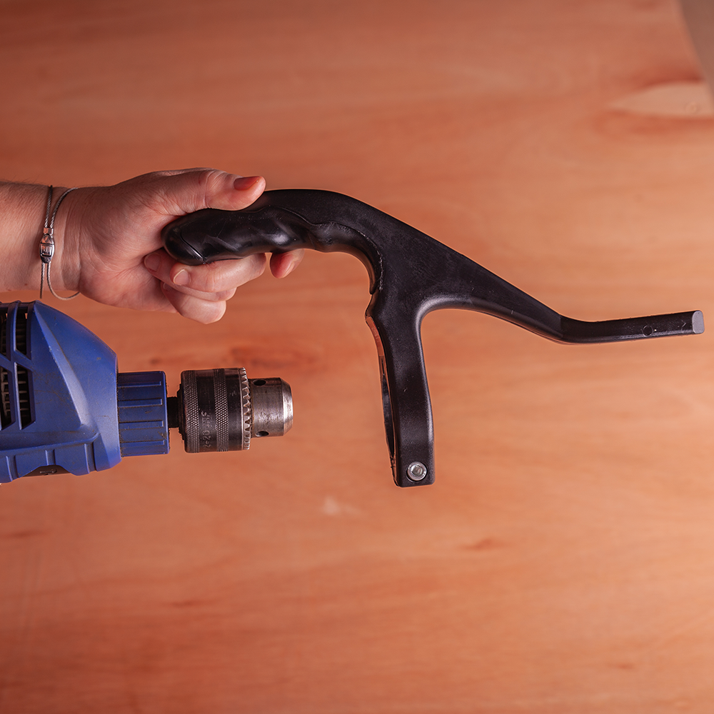 The one handed attachment fits onto the collar of a drill. Then gripping the CaNibble Nibbler.